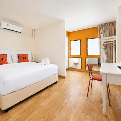 Standard room at Horange Phuket Town with an orange feature wall