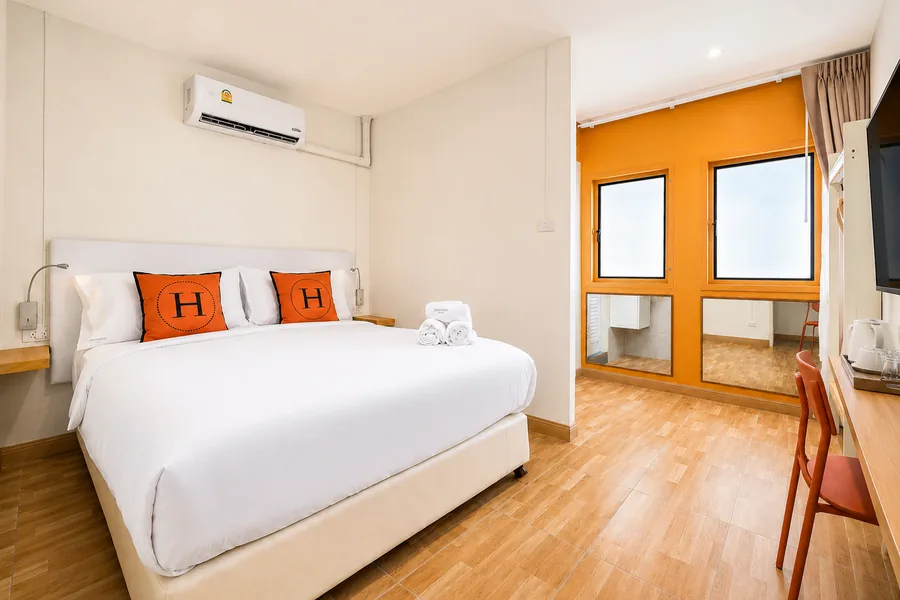 Standard room at Horange Phuket Town with an amber feature wall and a window